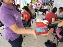 23 mujeres de Buga participan en un taller para crear cofres de amor y amistad, reutilizando envases de plástico